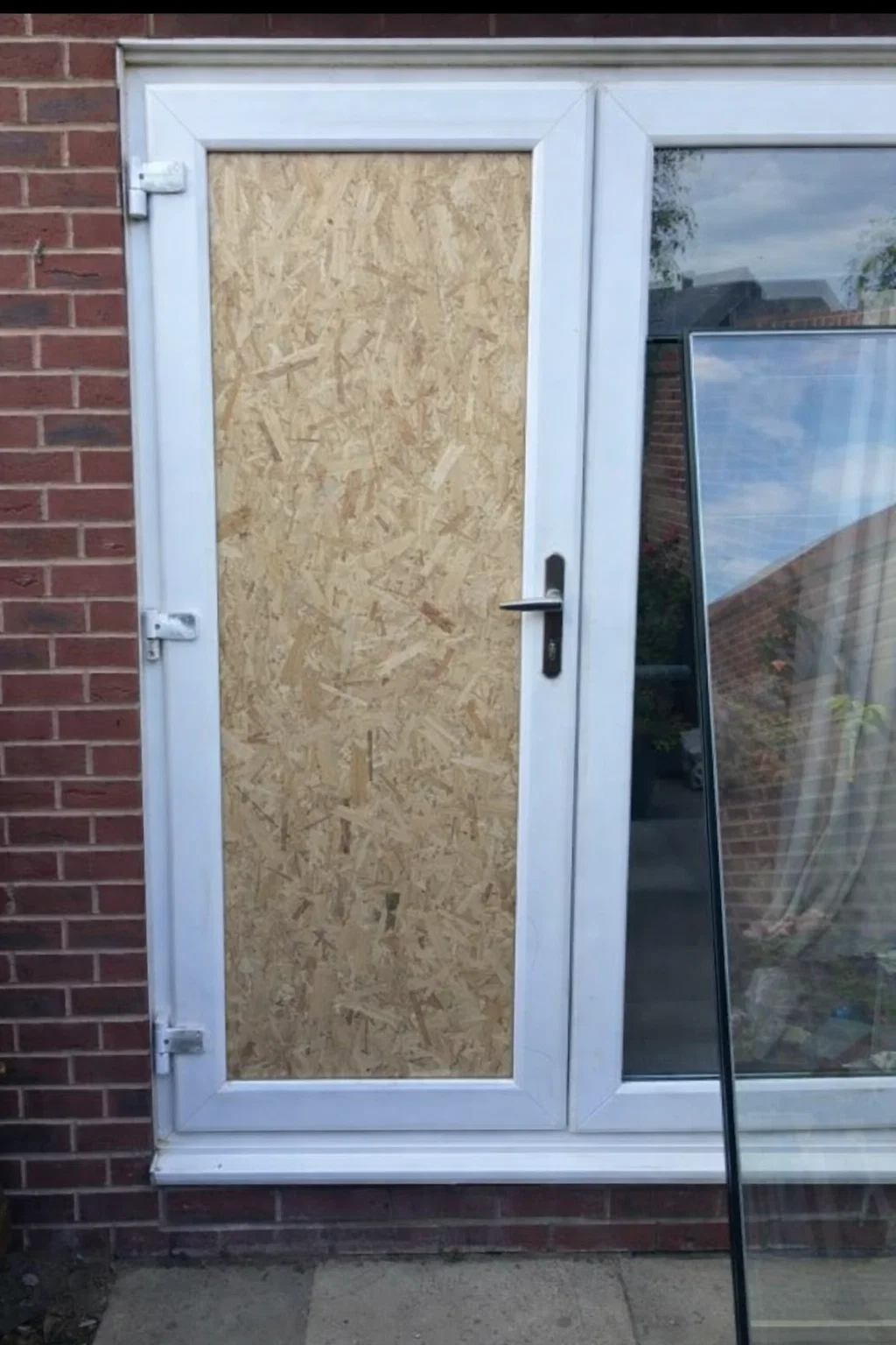 Sliding door repair technician working on a contemporary aluminum glass door